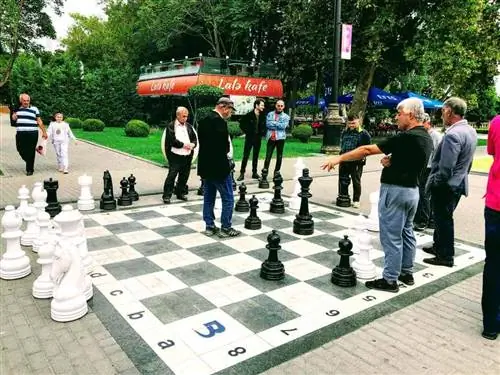 Местные жители играют в шахматы в натуральную величину на набережной Баку у Каспийского моря и Старого города.