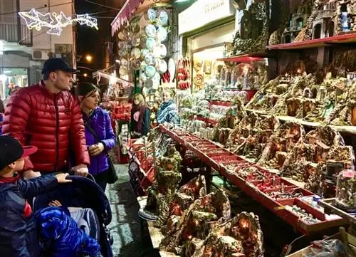 Семья просматривает варианты presepe в Неаполе.