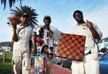 На пляже Кэмпс-Бэй есть несколько альтернативных вариантов шоппинга: Сэмюэл Калуле, Питер Каньерере и их друг демонстрируют свои поделки.