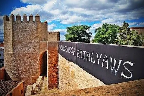 Знамена Аль-Моссасса свисают с обнесенной стеной цитадели. Фотографии Эмилио Пириса.