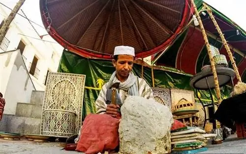 Один из торговцев, работающий над изделием ручной работы.