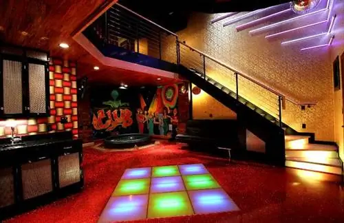 Клубный люкс отеля Adventure Suites с подсветкой для дискотек и гидромассажной ванной.