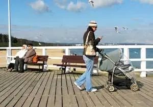 Местные жители наслаждаются лучами утреннего солнца в холодный мартовский день на пирсе Сопота.