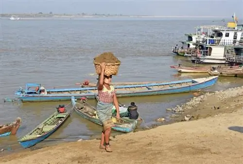 Таскает песок в Мандалае головой.