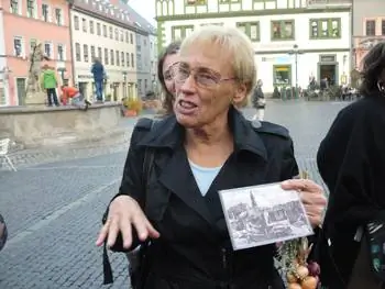 Гудрун Энгельхардт держит фотографию городской площади в Веймере в 1945 году.