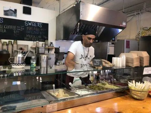 Зохар, владелец Yalla Vermont, готовит еду. Фотографии Айси Рид.