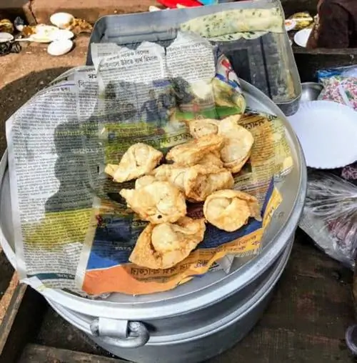 Местные газеты используются для вымачивания масла из свежезажаренных распутниц Terreti Bazaar