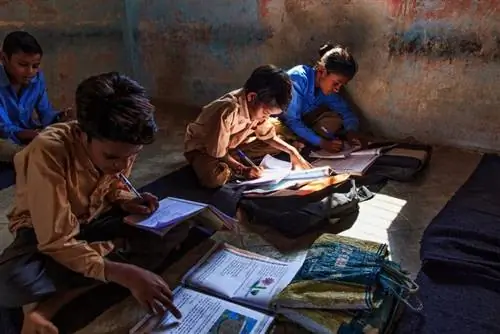 Деревенская школа племени гарасия. Дети сидят на ковриках - ни парт, ни доски, ни света - и внимательно слушают, что учительница обсуждает биологию.