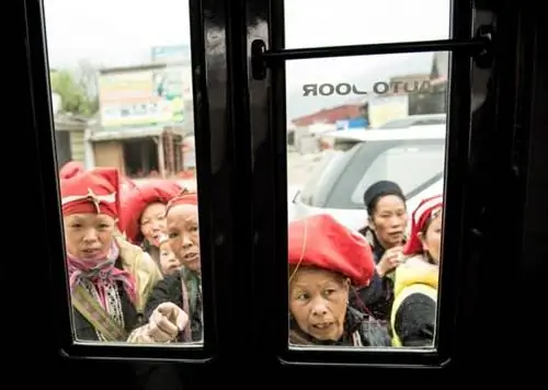 Женщины Красного Дао с нетерпением ждут у дверей автобуса, оценивая нашу группу.