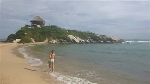 Туристы наслаждаются океаном перед знаменитой хижиной-гамаком Mirador в Кабо-Сан-Хуан. Сан Марта Колумбия.