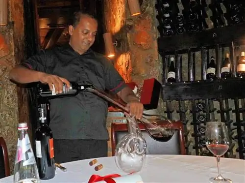 Сомелье декантирует прекрасное красное вино в погребе JA Manafaru, Мальдивы.