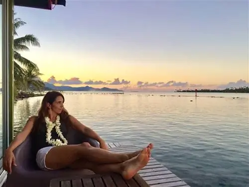 Мишель созерцает закат в бунгало над водой Гранды Маэвы на Раиатеа.