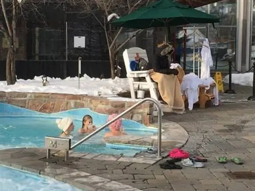 Спасатель укутан, пока гости наслаждаются бассейном с подогревом в Ritz Carlton Tremblant.
