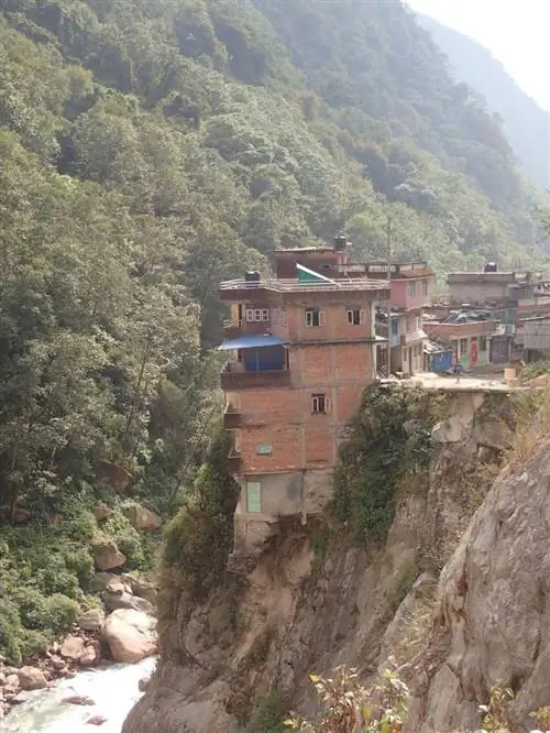 Дома цепляются за исчезающий склон холма в Татопани, Непал.