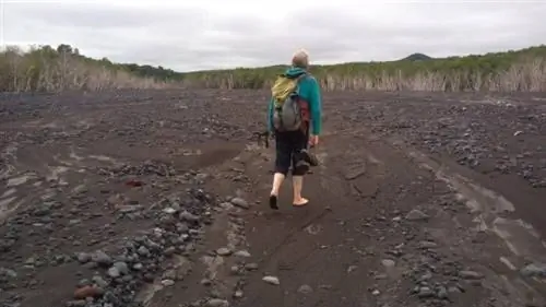 Сергей ведет через каменистое русло реки на Камчатке, Россия.