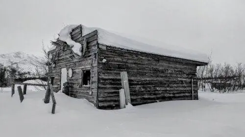 Старая заснеженная хижина в лагере Колдфут.