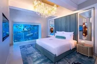 Подводный люкс в отеле Atlantis The Palm с окнами от пола до потолка, из которых открывается вид на аквариум курорта.