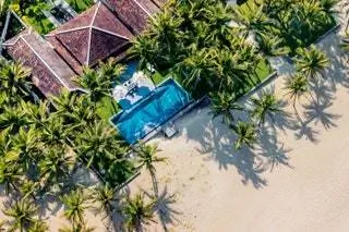 Вид на бассейн, сады и пальмы, окружающие отель Four Seasons The Nam Hai.
