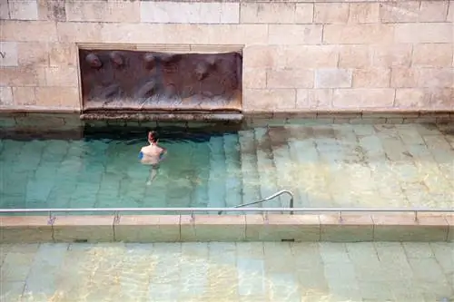 человек купается в горячем источнике Оренсе