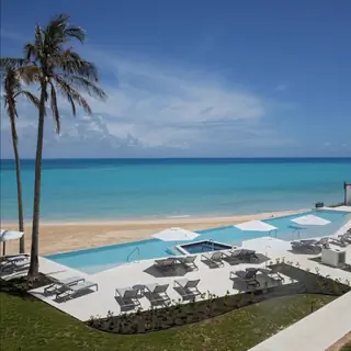 Бассейн с видом на песчаный пляж в отеле St. Regis Bermuda Resort.