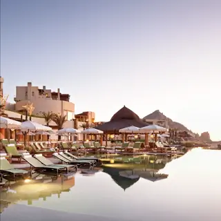 Шезлонги и зонтики у воды в отеле Waldorf Astoria Los Cabos Pedregal.