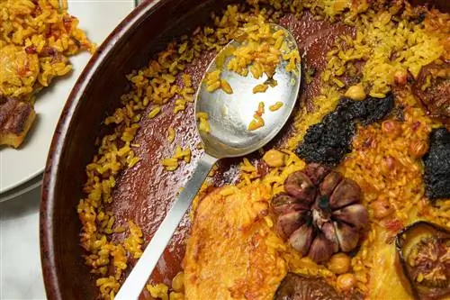 большое блюдо arrox con horno с кусочками чеснока и кровяной колбасы и сервировочной ложкой - еда Валенсии
