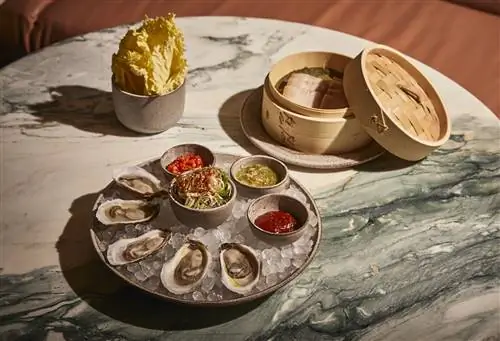 Устрицы и паровая корзина на мраморном столе в Oiji Mi