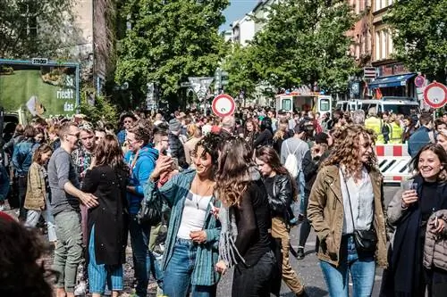 Счастливые молодые люди на многолюдной улице празднуют день труда в Берлине, Кройцеберг
