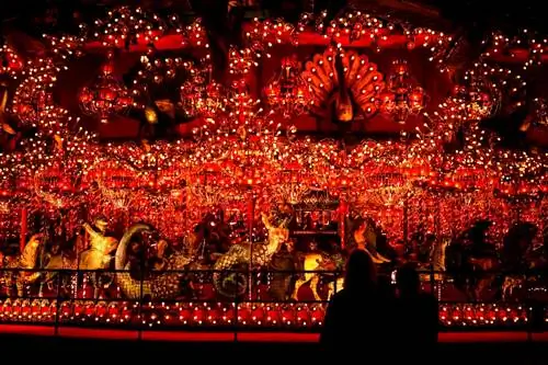 Посетители смотрят на карусель туристической достопримечательности «Дом на скале» с ее ослепительными огнями и мифическими существами; самая большая крытая карусель в мире.