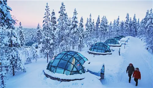 иглу и люди, гуляющие на арктическом курорте Какслауттанен в финляндии