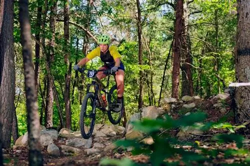 Женщина в велосипедном парке Массануттен на лесистой тропе