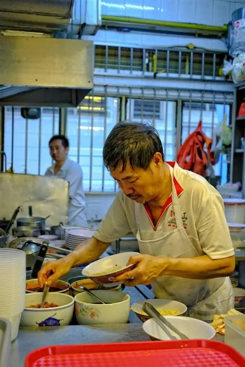 Шеф-повар Hill Street Tai Hwa готовит блюдо из лапши