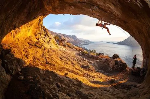 Женщина лезет в пещеру альпинистов