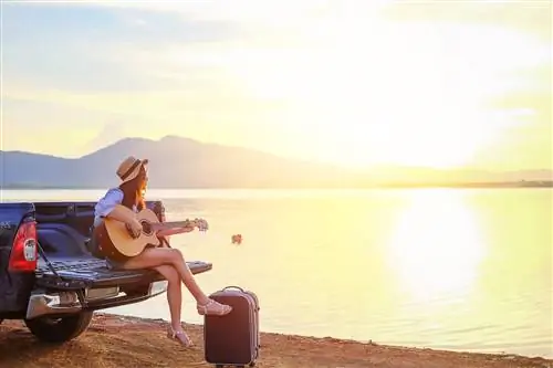 Женщина играет на гитаре на закате