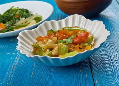 овощное рагу из чада в белой миске на синем деревянном столе