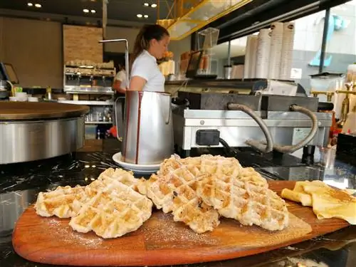 Люди делают бельгийские вафли в Брюсселе, Бельгия