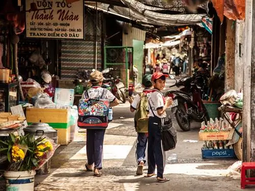 Школьник оглядывается на незнакомые лица в своей деревне.