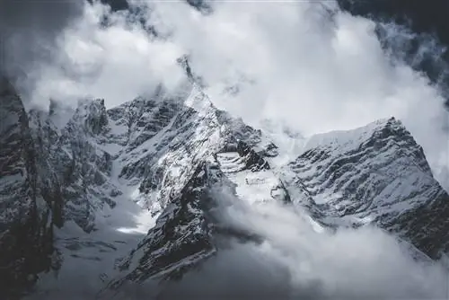 Облака плывут по заснеженным утесам под перевалом Ларке - трасса Манаслу.