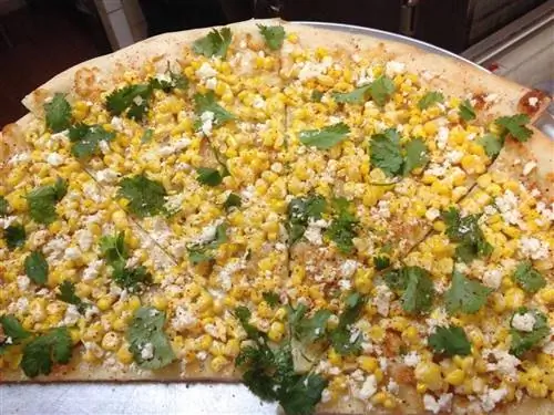 Пицца с кукурузой, сыром и гарниром из трав
