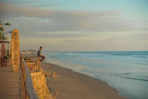 Молодой человек смотрит на море в городе Монтанита, Эквадор