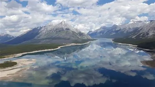 Гора Ассинибойн под облаками отражается в водном пути