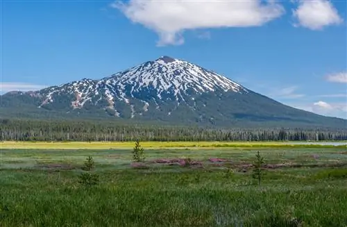 Гора Холостяк сфотографирована поздней весной с другой стороны озера на озере Спаркс, одном из озер на живописном переулке Каскейд-Лейкс недалеко от Бенда, штат Орегон.
