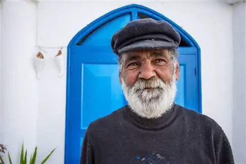 Седой бородатый мужчина позирует в Сиди-Бу-Саид