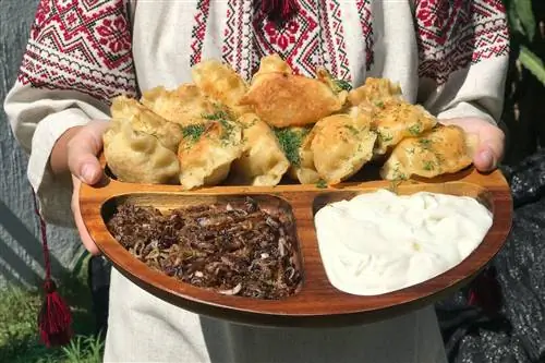 традиционная украинская еда на блюде, которое держит женщина