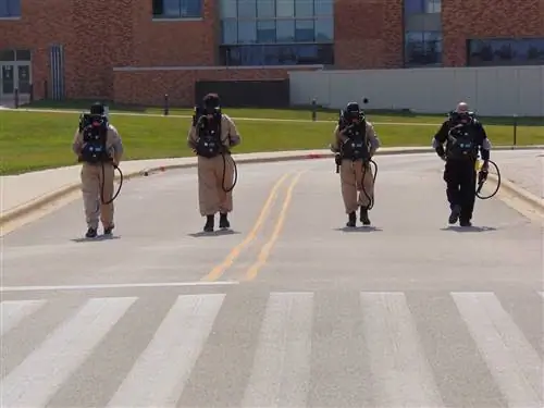 Четверо охотников за привидениями идут по пустой дороге во время приключения призраков округа Грейт-Лейк в Иллинойсе.