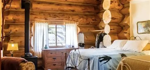 Деревенская спальня в Hideout Lodge с бревенчатыми стенами