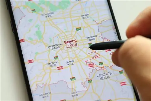 Рука держит стилус на телефоне с использованием Google Maps в Китае, устойчивость карт Google