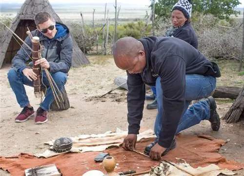 !Khwa ttu San Культурно-образовательный центр, Изерфонтейн, Западное побережье, Южная Африка - 28 августа 2018 г. Гид демонстрирует разведение огня, как это делается в культуре сан-бушменов.