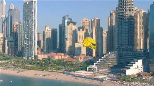 Аэрофотоснимок парасейлинга SeaWake на фоне небоскребов и пляжа