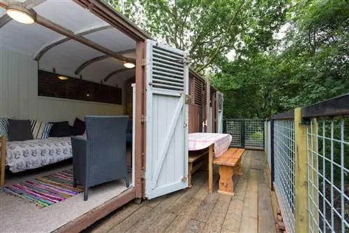 Переделанный вагон поезда превратил крыльцо Airbnb под деревья